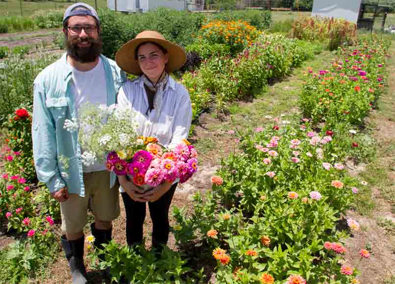 Couple standing in a flower field.