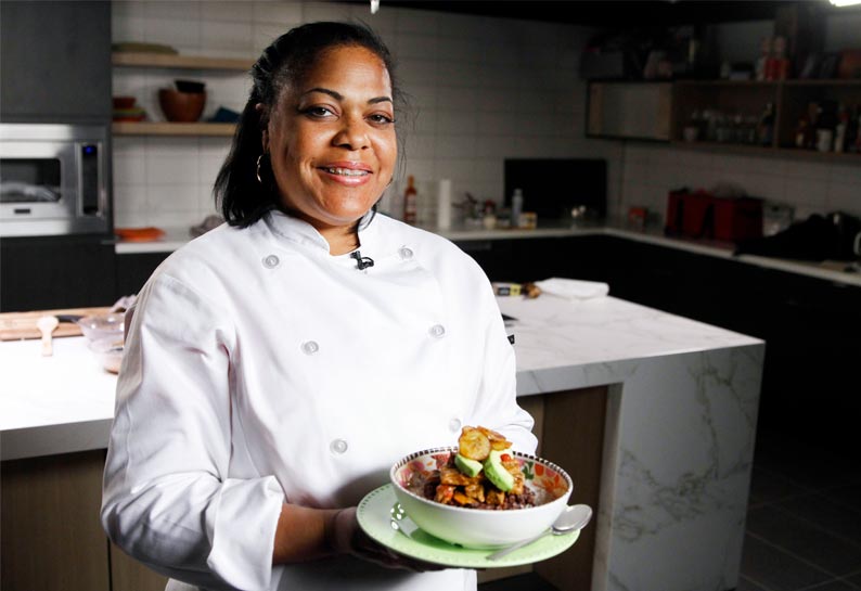 Woman chef holding a bowl of food.