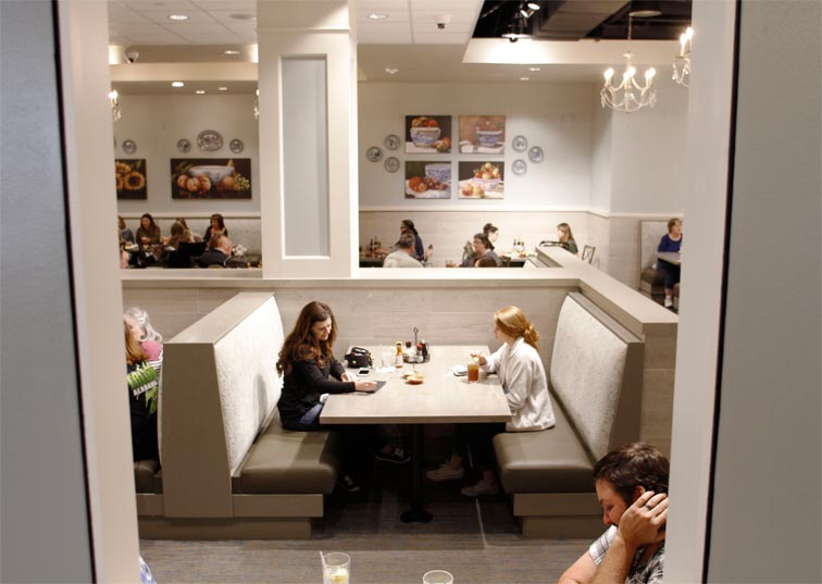 Two people eating at a booth.